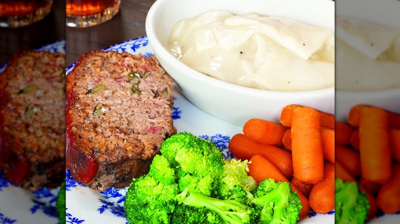A plate with meatloaf, broccoli, carrots, and dumplings