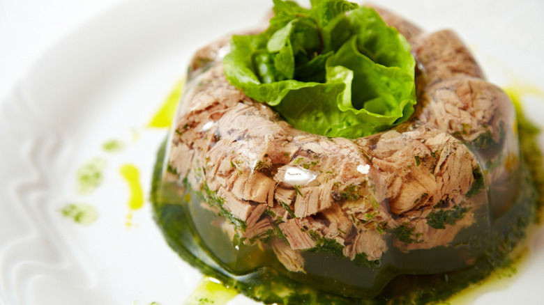 A gelatin salad with meat and lettuce on a table