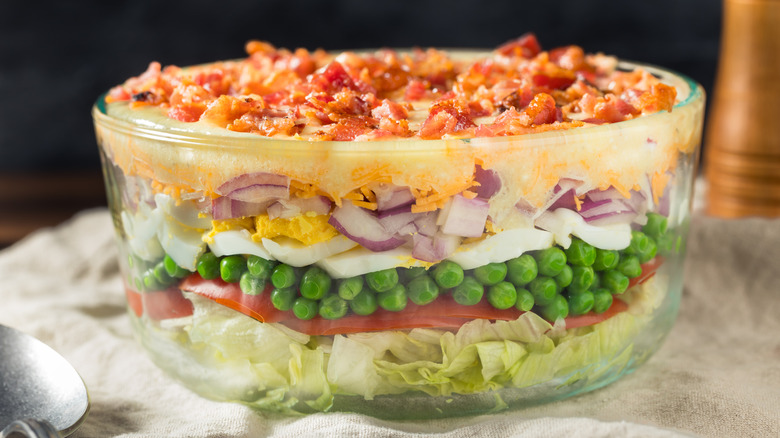 A seven-layer salad in a glass bowl