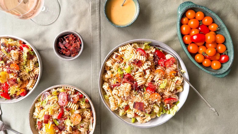Bowls of Over-the-Top BLT Pasta Salad with cherry tomatoes and bacon