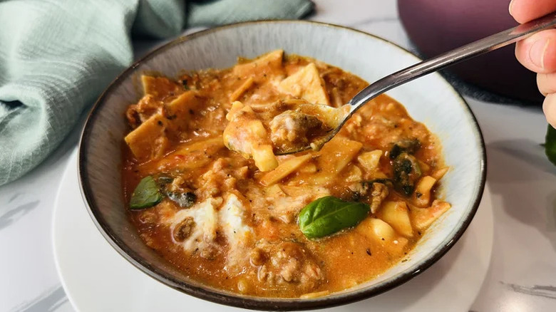 Spooning a bit of Super Creamy One-Pot Lasagna Soup form a large bowl