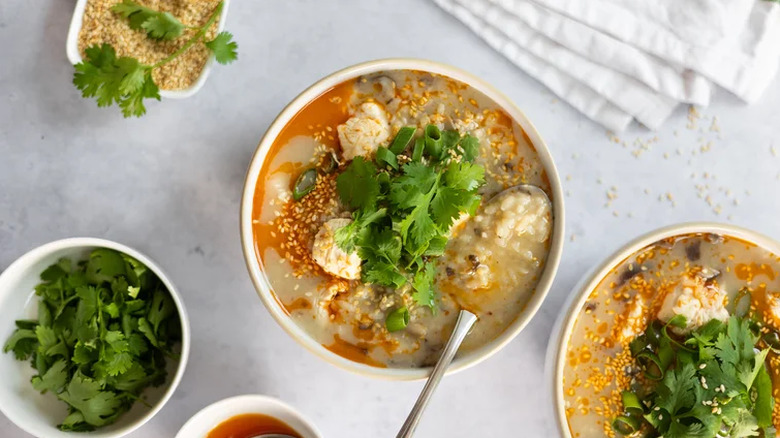 Comforting ginger chicken jook (rice porridge) in different bowls topped with cilantro leaves