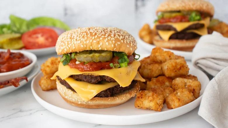 BBQ bacon smash burger on plate with tots