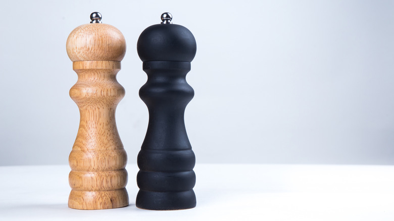 Salt and pepper mills side by side.