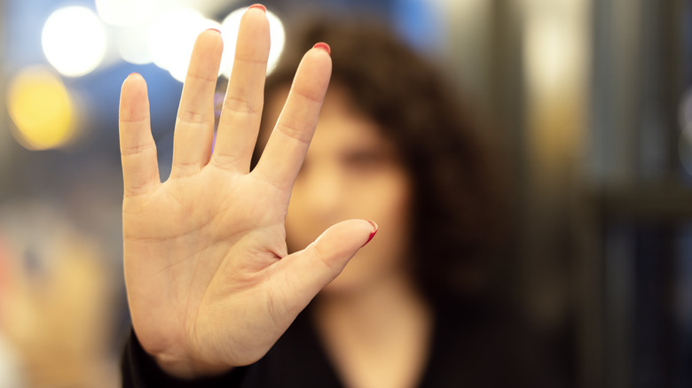 Woman holding hand up in a "stop" gesture