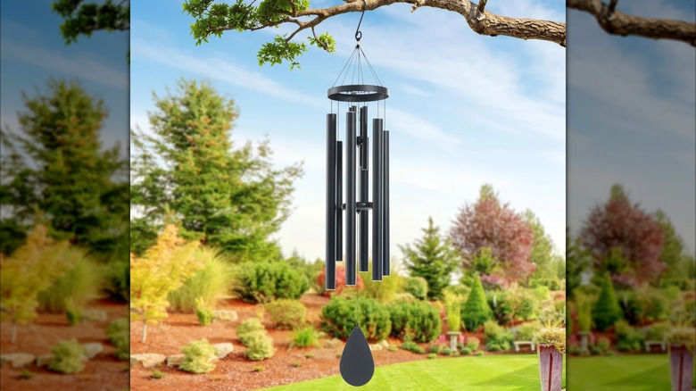 Black wind chime hanging from tree branch