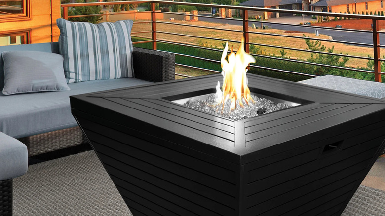 Black square table with built-in fire pit on a patio