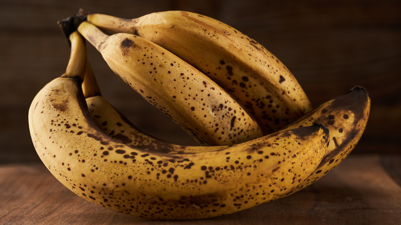bunch of overripe bananas sitting on a wooden countertop