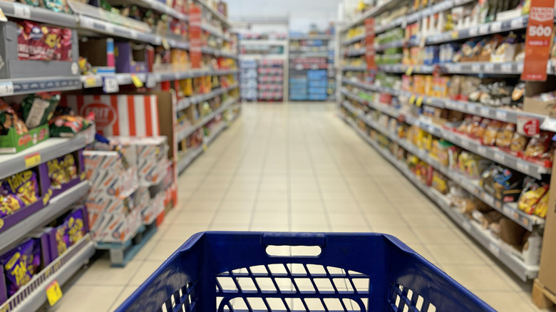 Shopping cart in the middle of grocery aisle