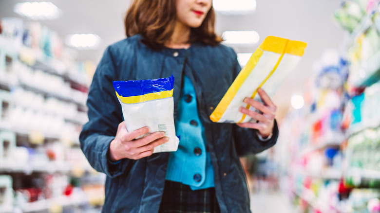 Woman holding packages of disinfectant wipes in store