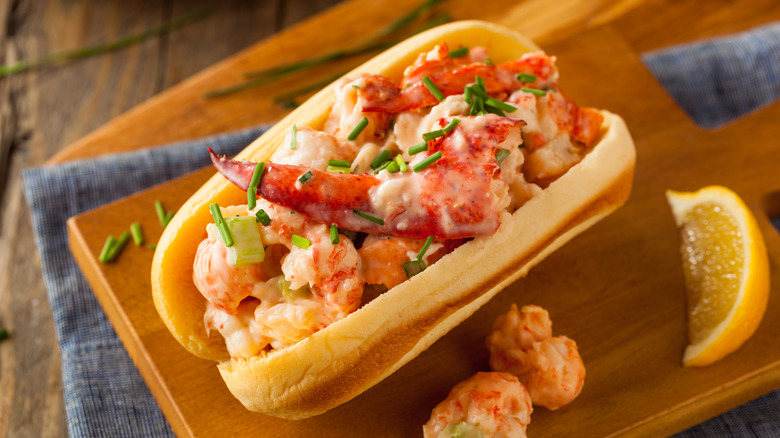 A lobster roll on a table with a wedge of lemon