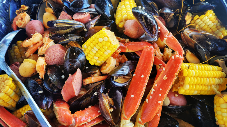 Diverse plate of seafood boil with corn on the cob