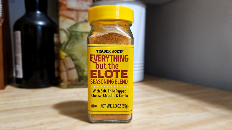 A seasoning jar with a yellow cap and yellow label, sitting on a kitchen counter