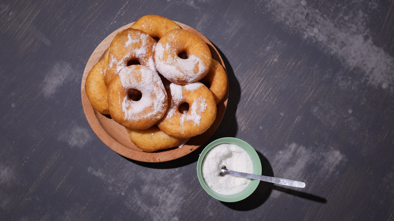 Overhead view of sugar-sprinkled doughnuts on a plate