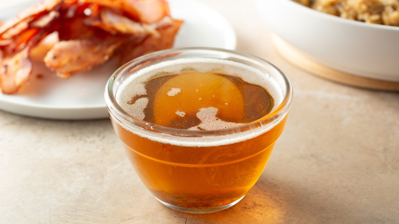 Bacon with bowl of bacon fat