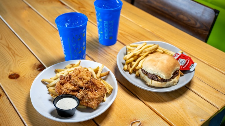 A plate of fried chicken and a burger at Chicken N Pickle