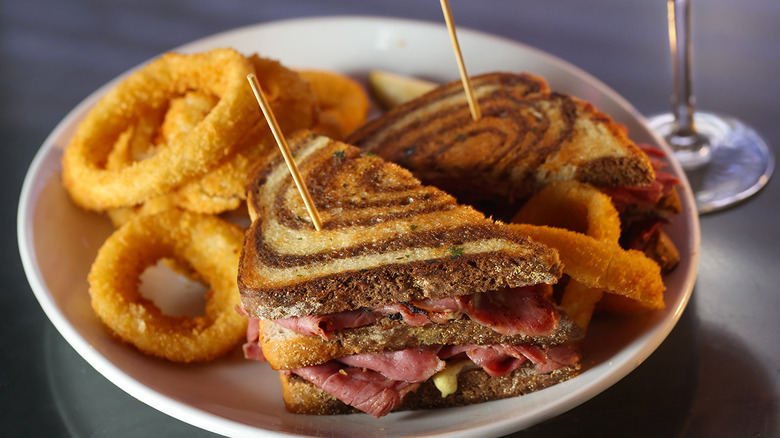 A pastrami sandwich with onion rings at Peppermill Restaurant & Fireside Lounge