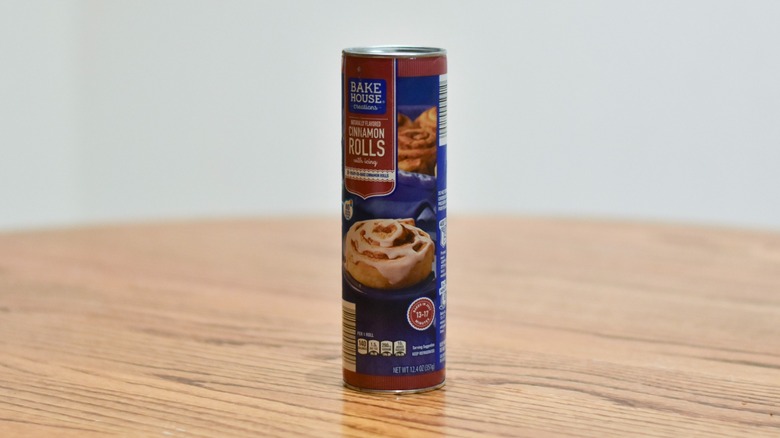 A container of cinnamon rolls on a wooden table