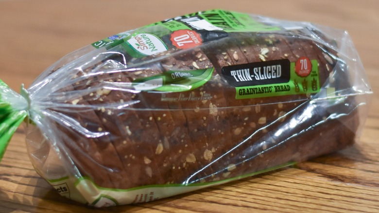 A loaf of thin-sliced Graintastic bread on a wooden table