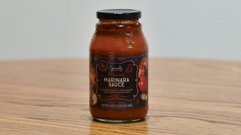 A jar of Specially Selected marinara sauce on a wooden table