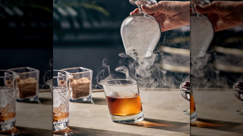 A person making a Smoked Old Fashioned at Bonefish Grill