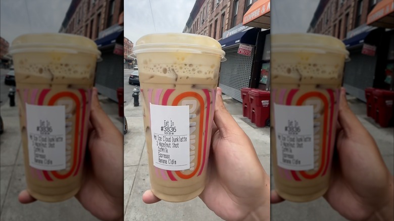 Image of hand holding Dunkin' Nutty Banana Cloud Dunkalatte