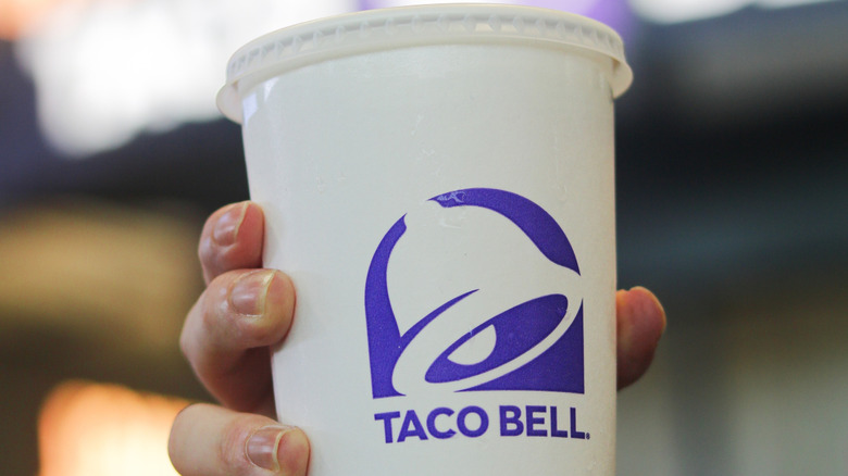 Hand holding a Taco Bell drink cup