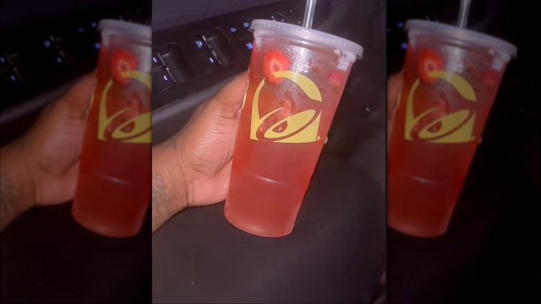 hand holding cup of Taco Bell Strawberry Tropics Energy Refresher