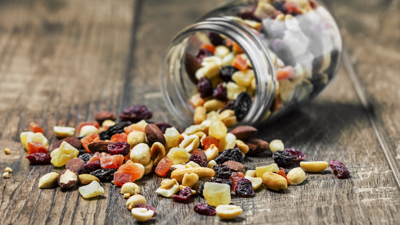 An overturned jar of trail mix on a wooden table