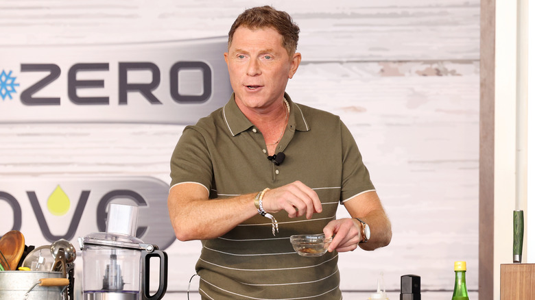 Bobby Flay preparing a seasoning mix at a cooking event