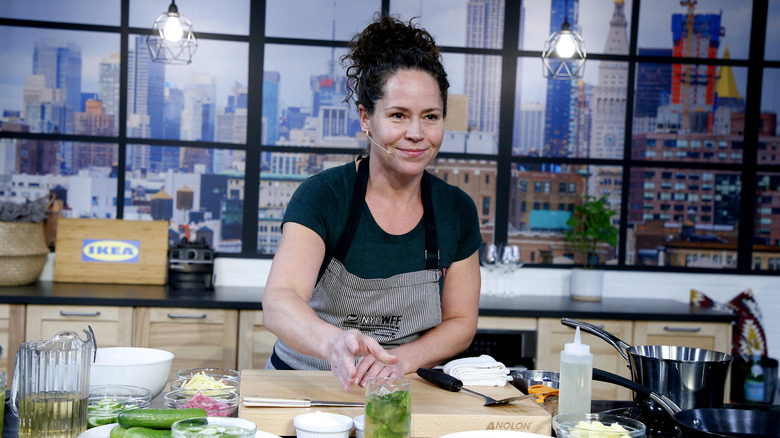 Stephanie Izard giving a cooking demonstration on a television set