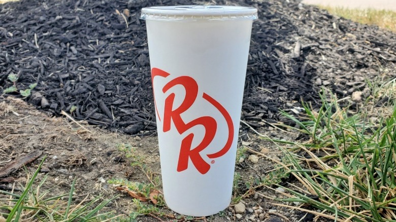 Red Robin chocolate milkshake sitting in grass and woodchips