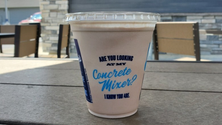 Culver's chocolate milkshake sitting on outdoor brown table