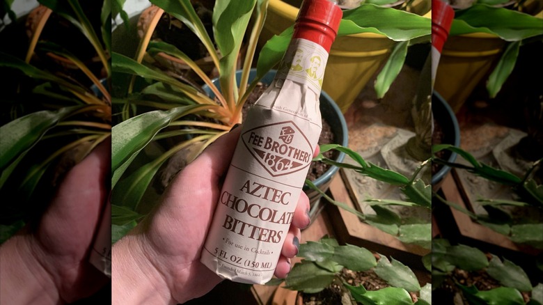 Person holding container of Fee Brothers Aztec Bitters