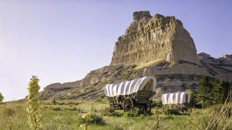 frontier wagons in front of Scout's Bluff, NE, a stop along the Oregon Trail