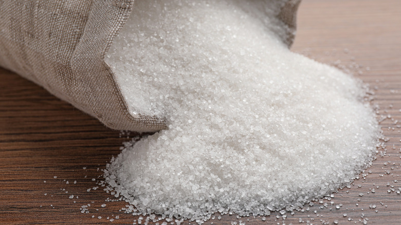 granulated sugar spilling out of a white sack