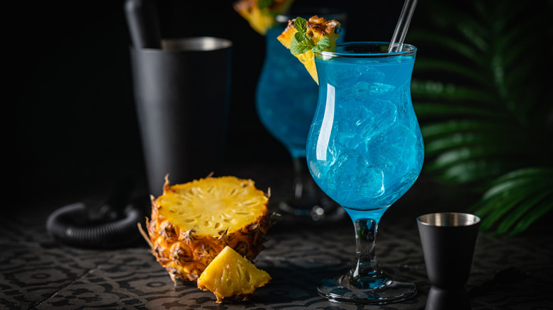 Blue Hawaii cocktail with pineapple in the background
