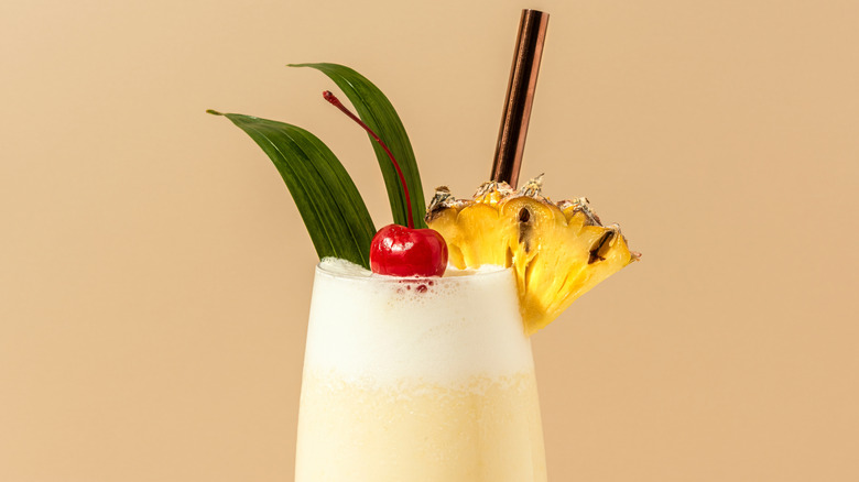Pina colada with pineapple and cherry garnish