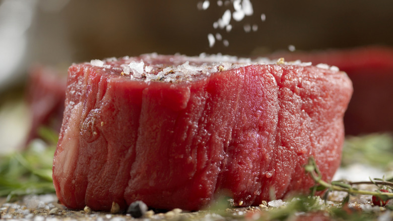 Sprinkling salt on filet mignon