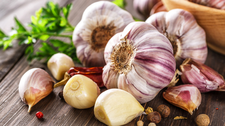 Heads of garlic and a few cloves on wooden surface