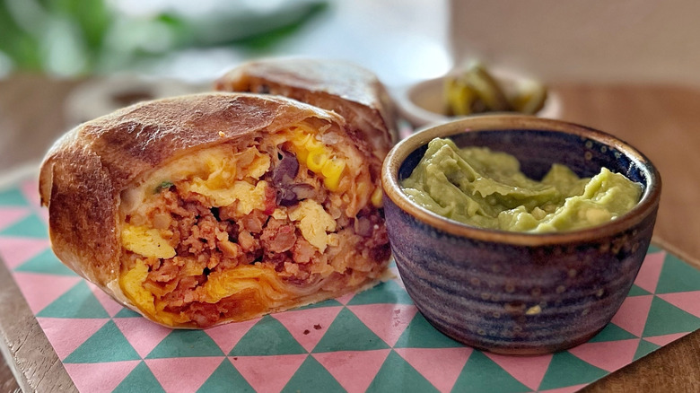 Breakfast burrito with beans and guacamole side
