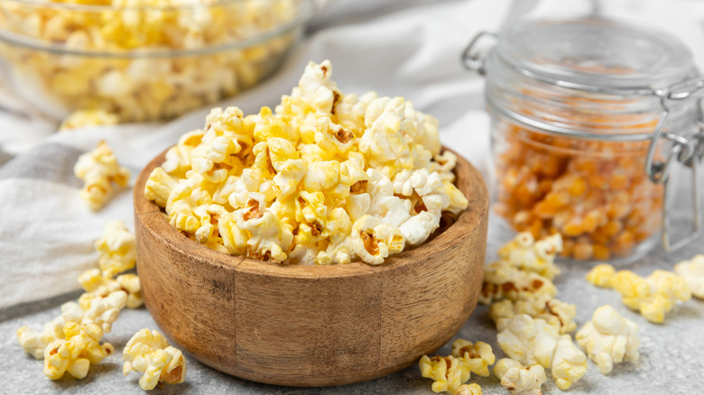 A glass bowl of buttery yellow popcorn