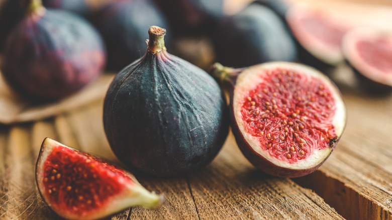 Whole and sliced figs on a wooden table