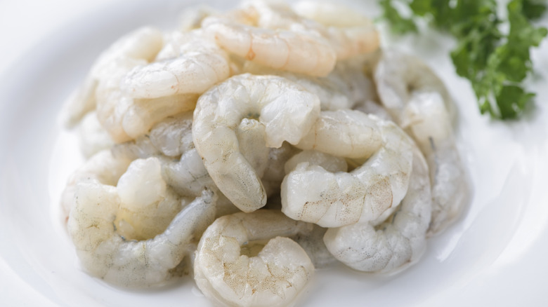 Raw peeled shrimp on a white plate