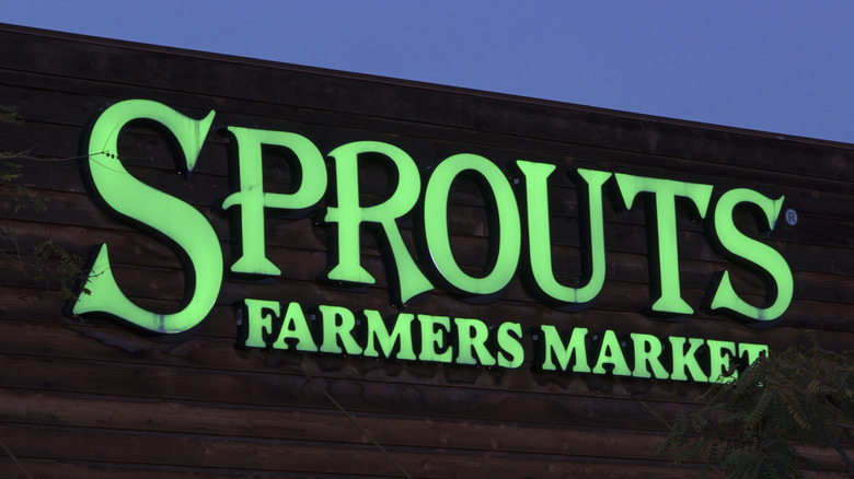 A close-up image of the Sprouts Farmers Market logo on a storefront.