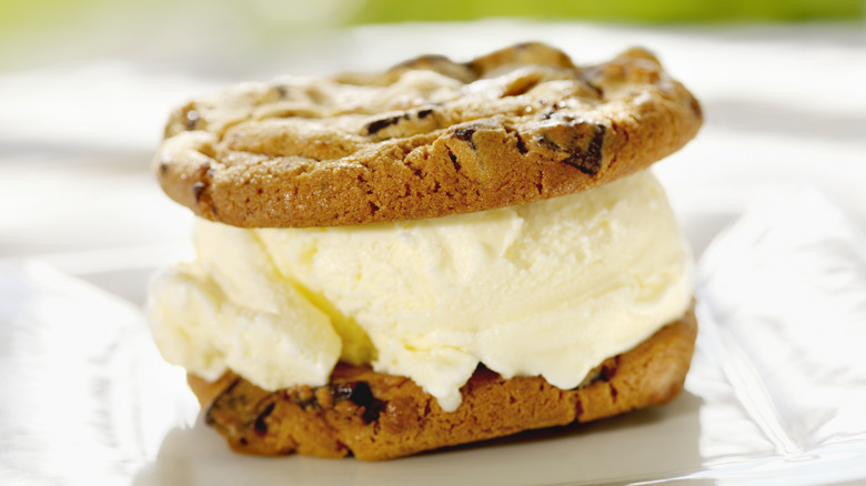 Vanilla ice cream in between two chocolate chip cookies