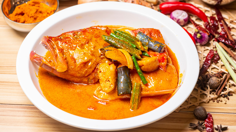A bowl of fish head curry with vegetables