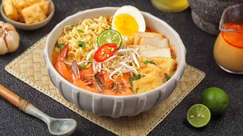 A bowl of Singaporean laksa on a woven placemat