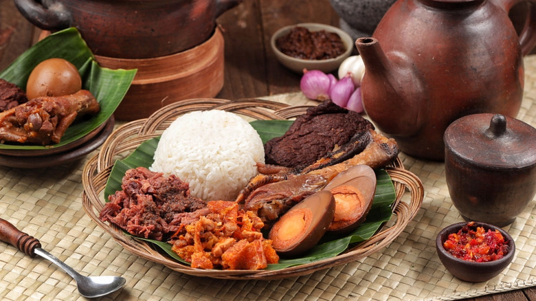 A plate of gudeg with spiced jackfruit, hard boiled egg, chicken, and rice