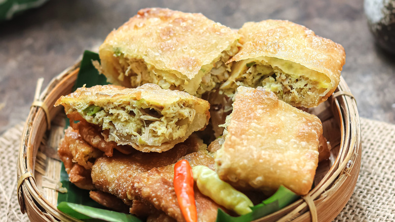 A basket of martabak telur with chili peppers